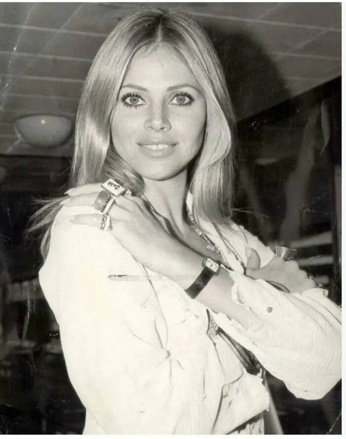 Black and white 1970s portrait of a woman showcasing retro fashion style