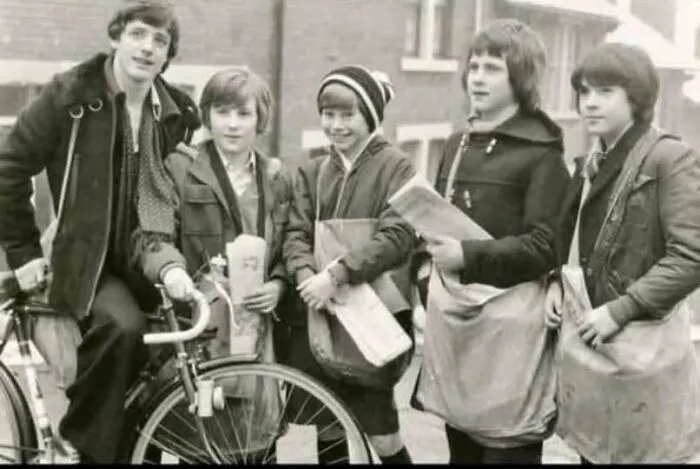 Vintage 1970s photo of young newspaper delivery boys with a bicycle