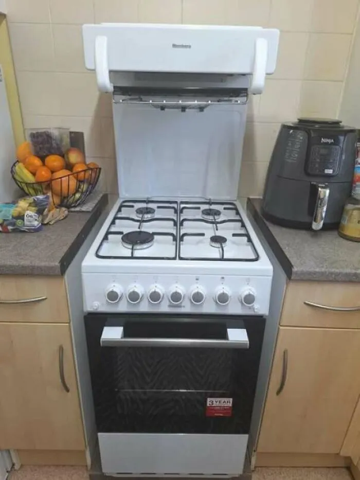 1970s white freestanding gas stove and oven in a kitchen setup with nearby appliances