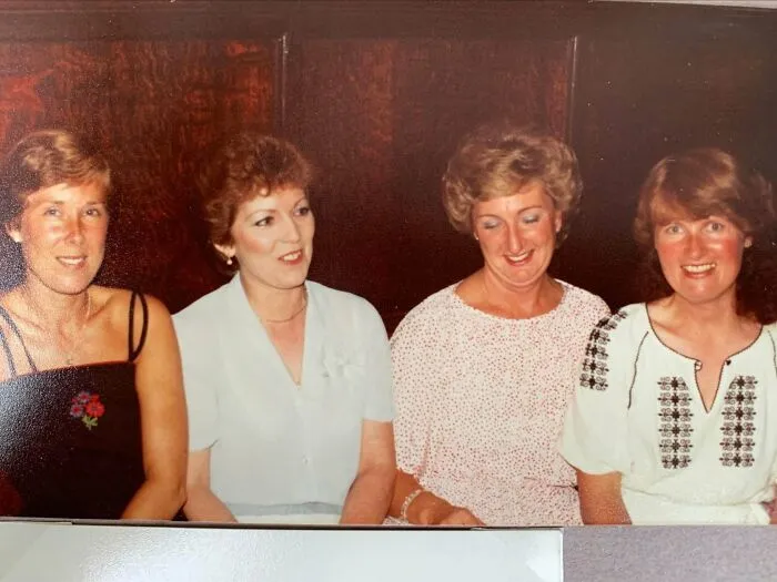 Four smiling women seated together in candid '70s photos featuring vintage hairstyles and outfits.