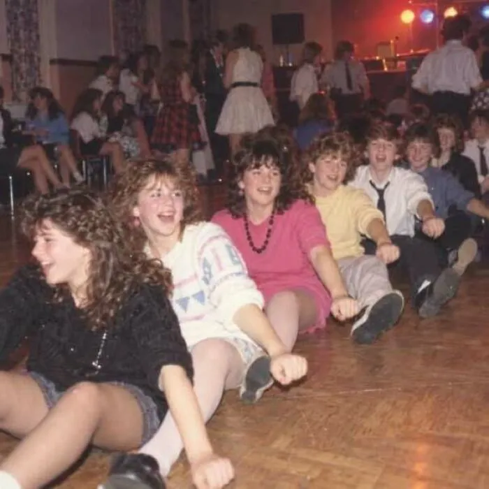 Group of teens dancing and having fun at a 1970s school dance party