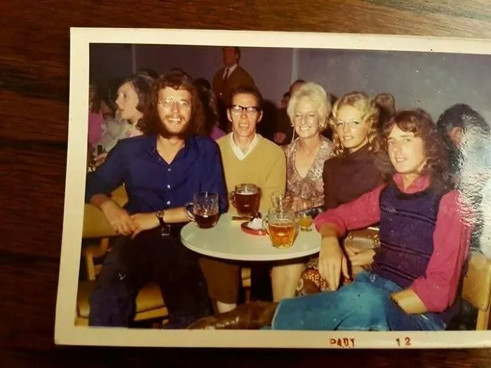 Group of friends enjoying drinks at a 70s bar or pub