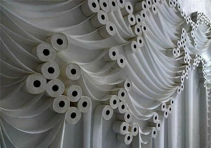 A questionable wedding arch decorated entirely with rolls of toilet paper draped like curtains.
