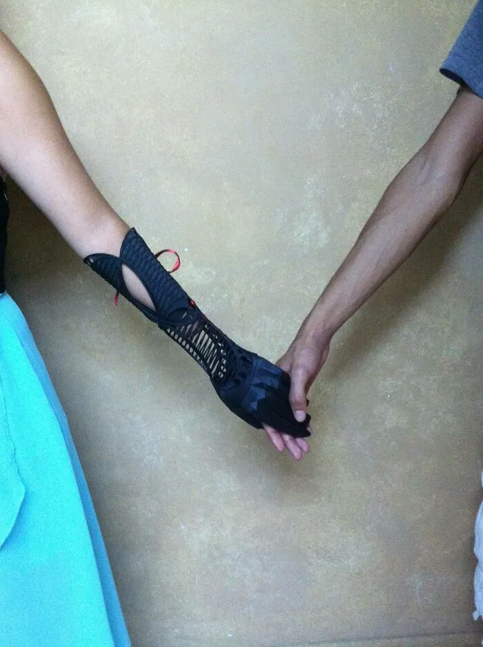 A black 3D printer prosthetic arm held by another person