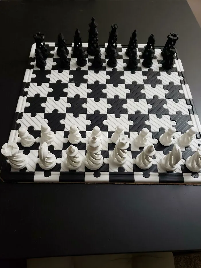 A custom chess set with spiraling pieces and a jigsaw board created by a 3D printer.