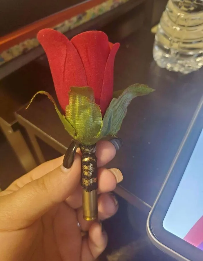 A red rose boutonniere in a bullet casing for questionable wedding moments