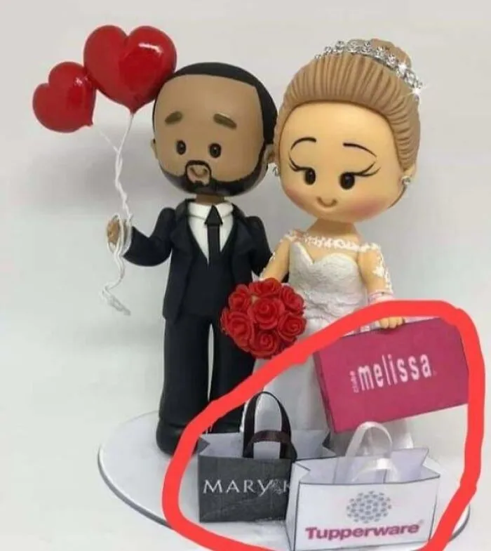 A wedding cake topper doll surrounded by miniature shopping bags, a questionable wedding moment