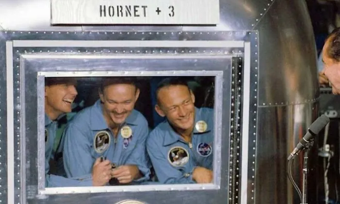 Apollo astronauts inside spacecraft window, iconic space exploration history