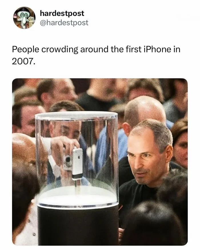 Funny post featuring Steve Jobs looking at the first iPhone inside a glass display.
