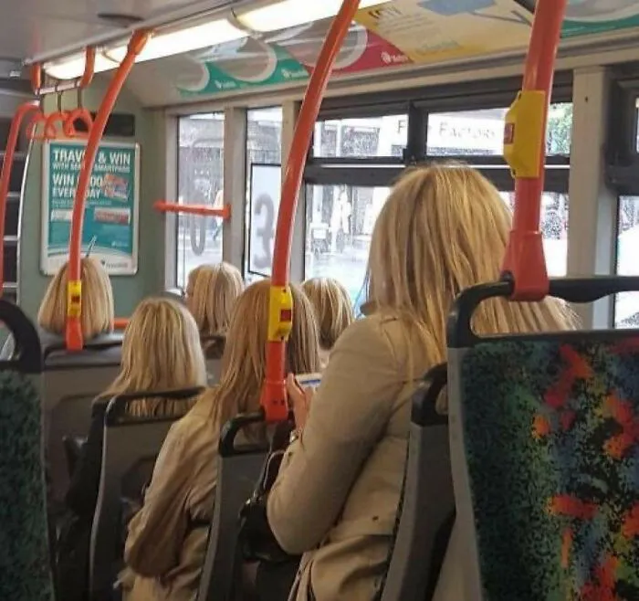 Multiple blonde women in beige coats sitting on a bus look like strange photos of repeated real-life glitches.