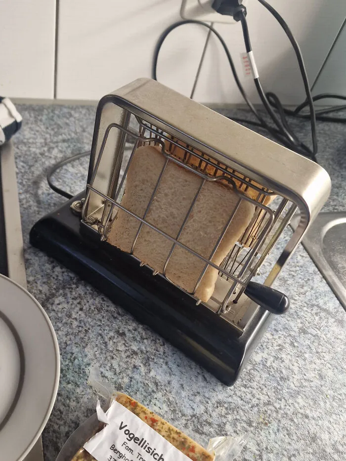 An old-fashioned metal toaster with bread inside, showcasing functional retro gadgets.