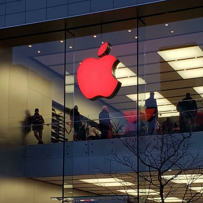 A large glowing red Apple logo on a glass building front captured in strange photos.