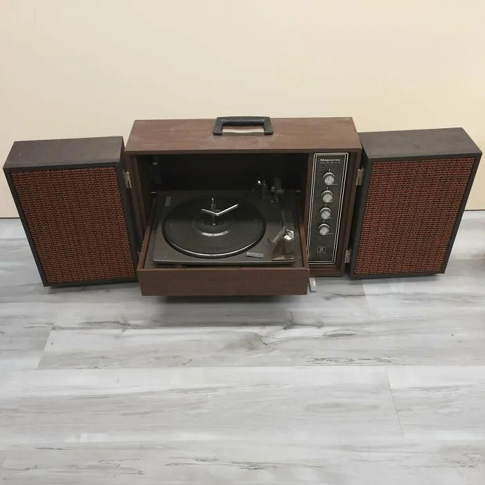 A portable wooden record player with fold-out speakers demonstrating artistic retro gadgets technology