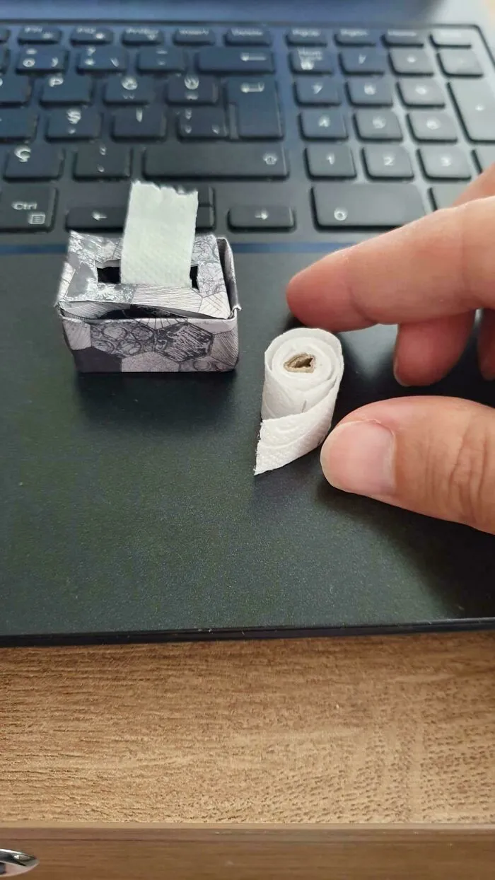 Miniature paper tissue box and toilet paper roll on a laptop keyboard, shown in wholesome pics of dads being creative.