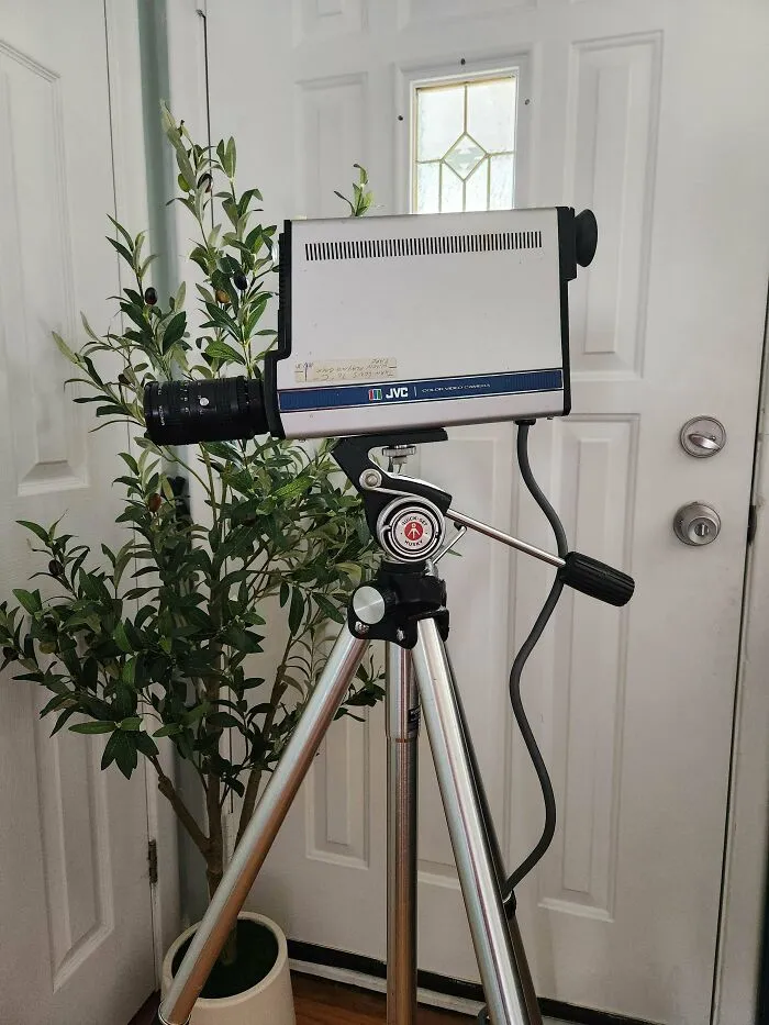 A vintage JVC video camera on a tripod stand showcasing retro technology and classic design.