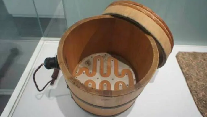 A vintage electric rice cooker made of wood, showcasing old-school engineering and retro gadgets.