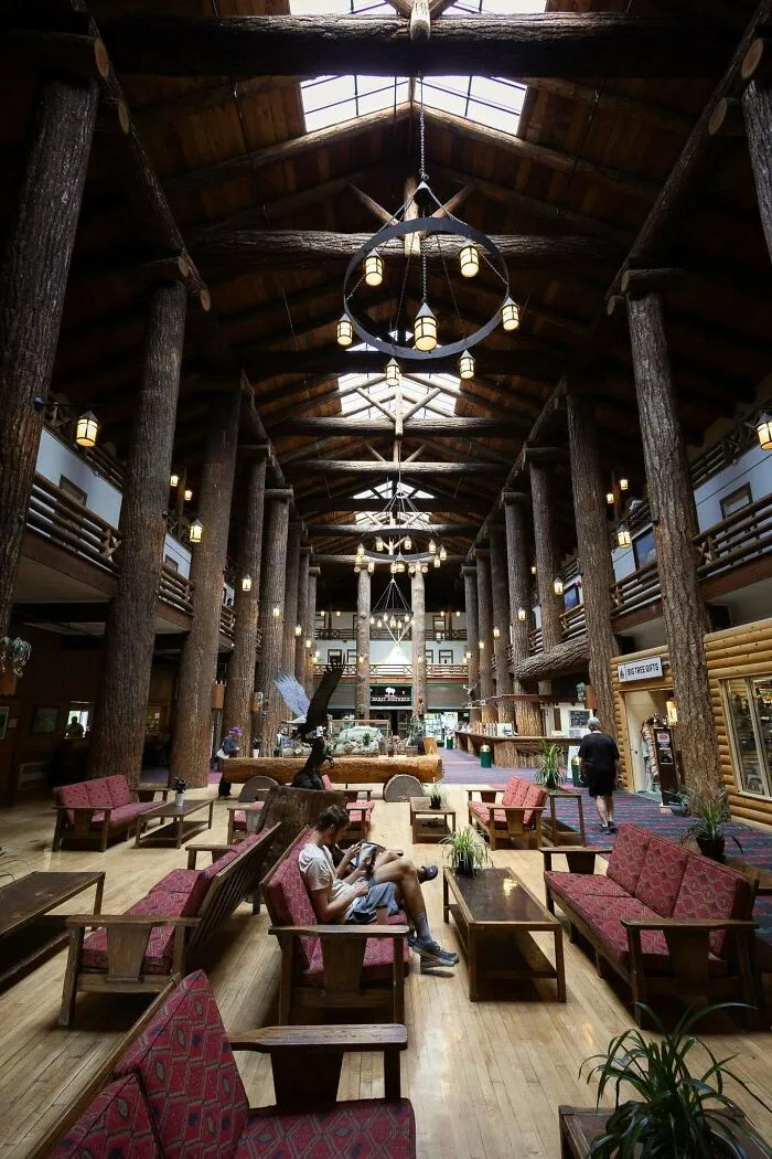 Spacious lodge interior with massive wooden columns and chandeliers, showcasing architectural masterpieces