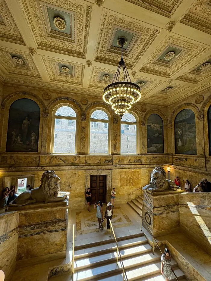 Marble staircase with lion statues in a historic building featuring stunning architectural masterpieces
