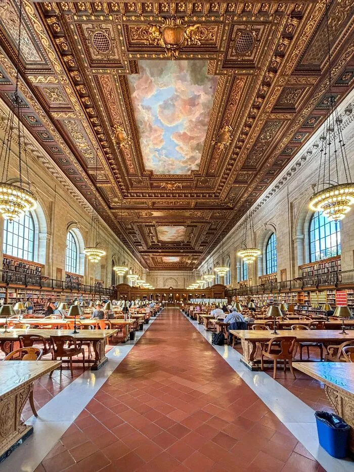 Grand historic library hall with ornate ceiling painted with clouds, an architectural masterpiece