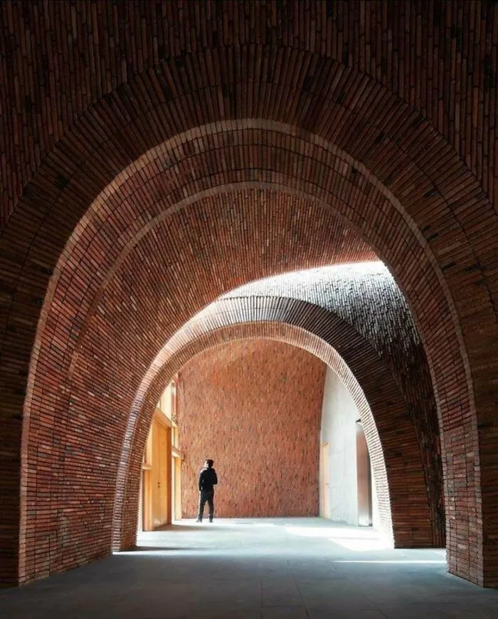 Interior of a building with sweeping brick arches, demonstrating impressive architectural design