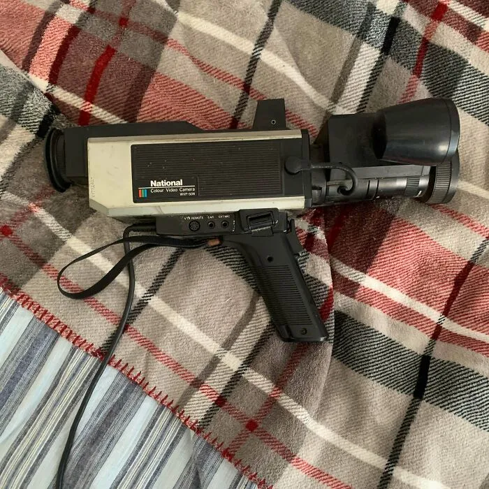 A vintage National video camera resting on a plaid blanket, highlighting classic retro gadgets technology.