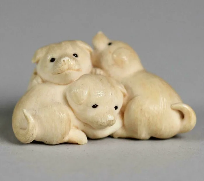Intricately carved ivory figurine of three small puppies