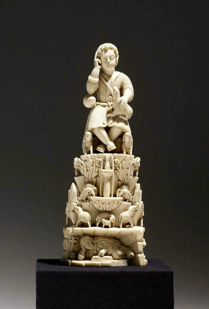 Intricately carved ivory statue featuring a seated figure and animals artifact