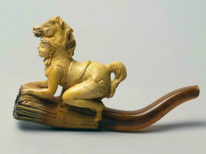 Carved pipe shaped like a mythical creature with horse and human features from interesting artifacts