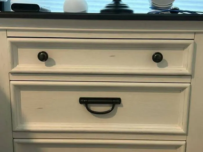Cabinet drawer handles resembling two eyes staring on white wood cabinet