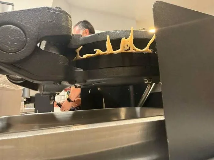 Waffle maker with batter shaped like small smiling faces appearing to stare