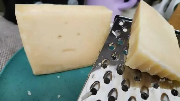 Block of cheese with holes that look like eyes and a mouth