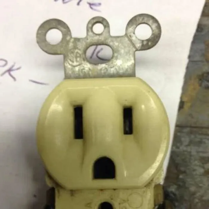 Electrical outlet resembling a face staring with round eyes and open mouth