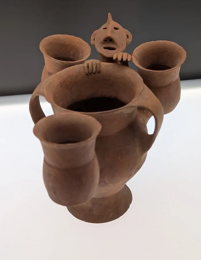 Unusual clay vessel with a small humanoid figure peeking over the rim representing strange artifacts
