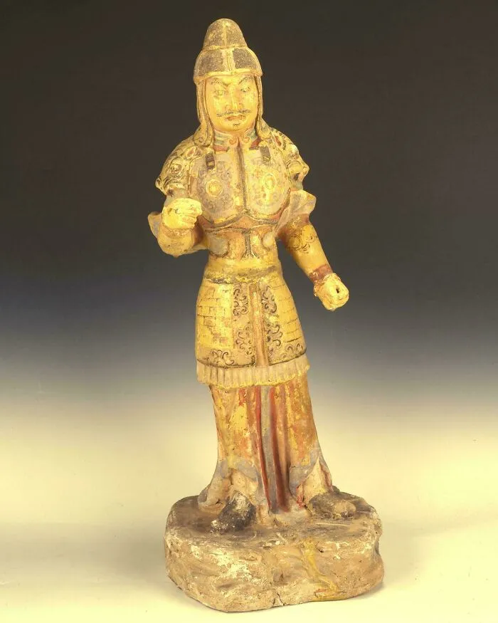 Historic pottery statue of a warrior wearing armor and helmet