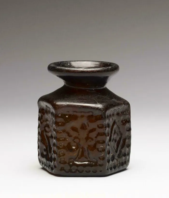 Small dark glass bottle with embossed designs, an interesting strange artifact discovery