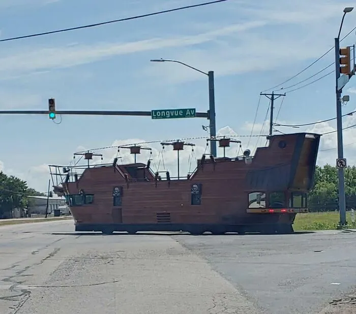 Strange photos of a pirate ship modified as a road vehicle stopped at a street intersection.