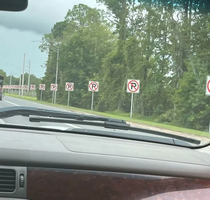 Strange photos showing a long road lined with excessive repeated no parking signs.