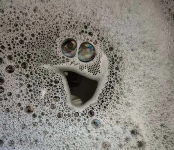 Soap bubbles forming a happy face in foam