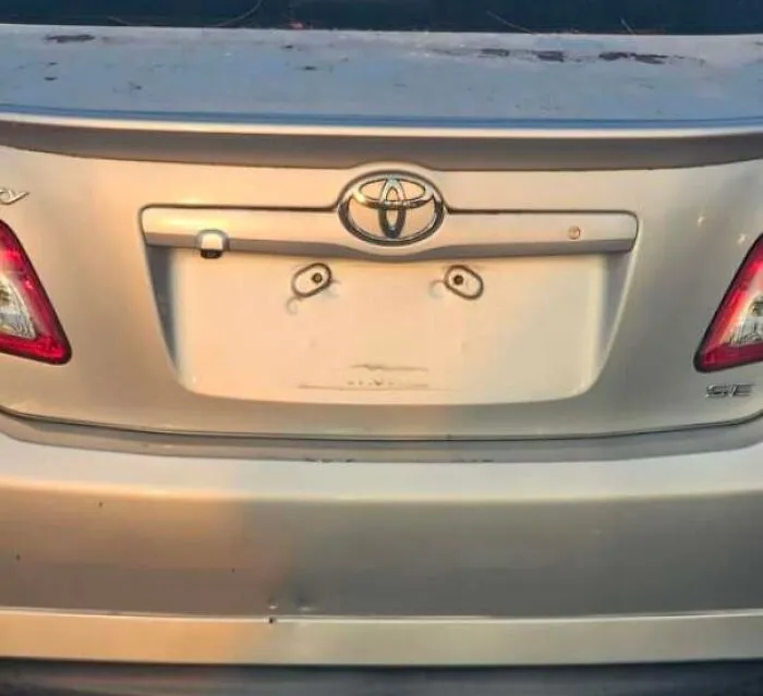 Car rear with dents and bolts resembling eyes and a surprised face.