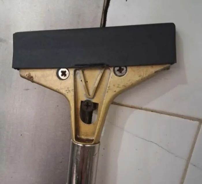 Window squeegee with metal and rubber parts forming a staring face