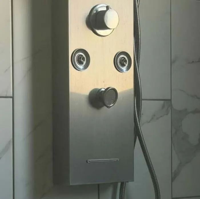 Shower panel with knobs and nozzles resembling a staring face