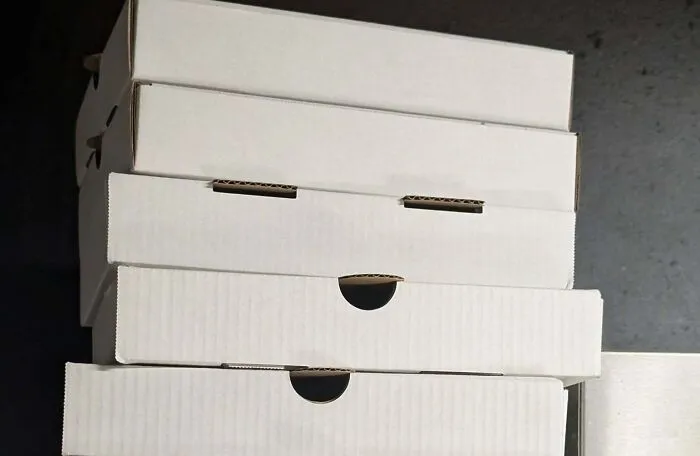Stack of white boxes with openings resembling staring faces