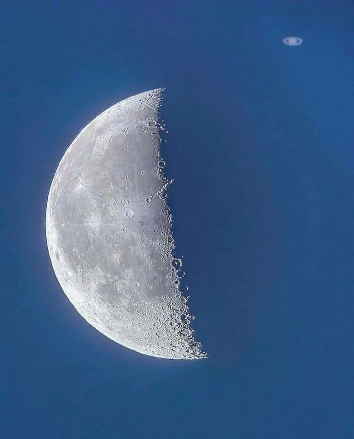 A detailed view of the crescent moon with Saturn visible in the background, a perfect celestial moment.