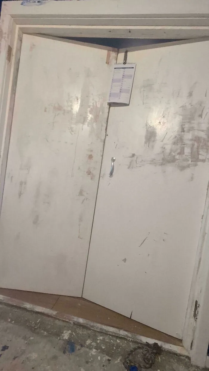 Messy paint streaks and a makeshift calendar on bi-fold closet doors, showcasing a poor home improvement effort