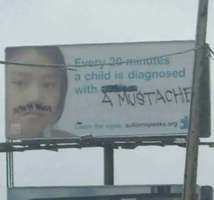 Creative act of vandalism on a public billboard altering the text to read diagnosed with a mustache