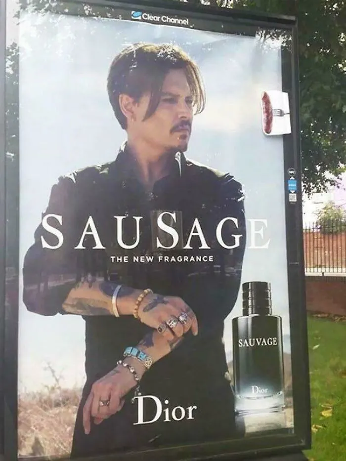 Vandalism changing a Sauvage perfume ad with Johnny Depp to read Sausage with a small sausage on a fork