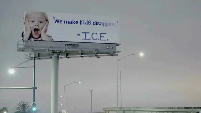 An altered billboard with political graffiti about ICE, showcasing clever vandalism on public signs.