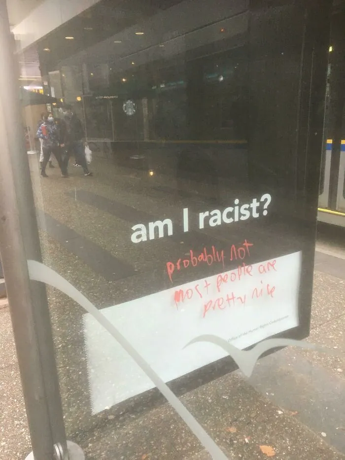 Gentle acts of vandalism with graffiti replying to a bus stop question about racism