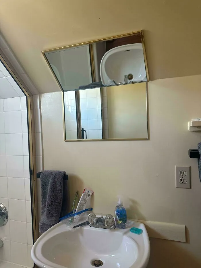 An awkwardly placed bathroom mirror reflecting a home renovation mistake.