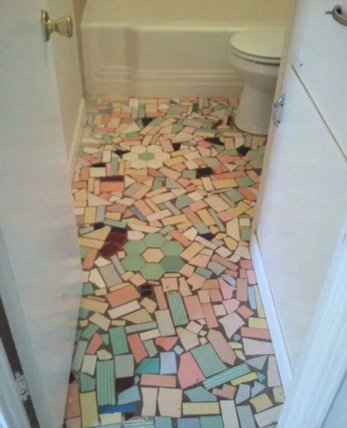 Mismatched and poorly laid mosaic tile floor showing a failed bathroom DIY renovation.
